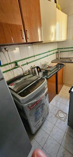 una cucina con un lavello e un grande contenitore di Bedspace in room a Sharjah