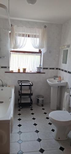 ein Bad mit einem schwarz-weißen Fliesenboden in der Unterkunft Cottage by the sea in Enniscrone