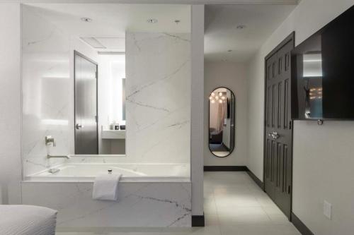 a bathroom with a tub and a sink and a mirror at Hotel 43 Boise in Boise