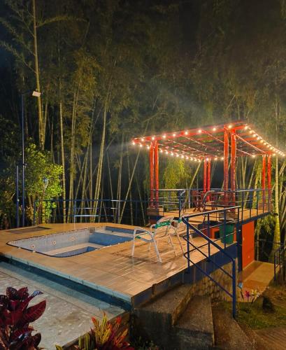 a swimming pool with lights on a deck at night at Finca privada de lujo Casalegre in Pance