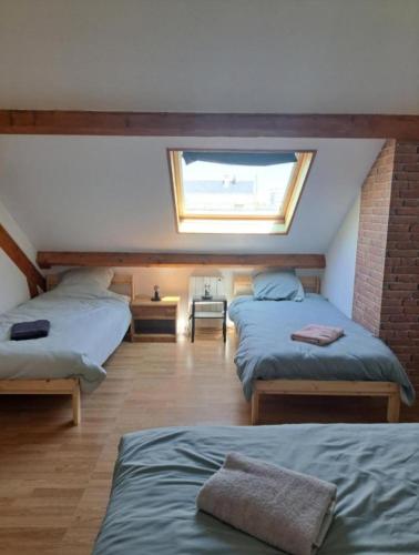 a room with three beds and a window at Colocation in Trignac