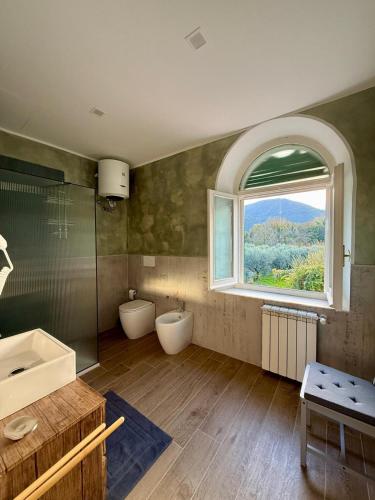 a bathroom with two toilets and a large window at Grand Tour - Cascata delle Marmore in Le Marmore