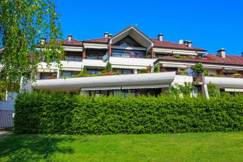 un grande edificio con una siepe di fronte ad esso di Residenz La Vela a Baveno