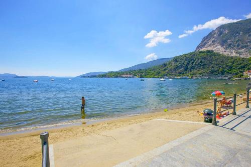 Un uomo in piedi in acqua sulla spiaggia di Residenz La Vela a Baveno