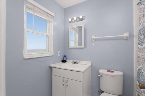 ein weißes Badezimmer mit Toilette und Waschbecken in der Unterkunft The Beach Bum in Ponte Vedra Beach