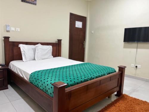 a bedroom with a bed and a flat screen tv at Beatrice court in Accra