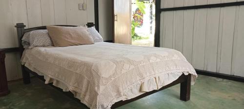 uma cama com um edredão branco num quarto em Duni Hostal em Estación El Salto
