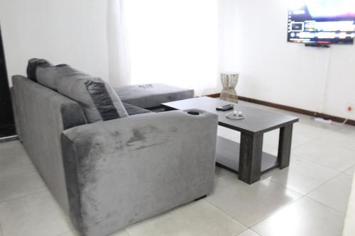 a living room with a couch and a coffee table at Golf Course Apartment in Maseru