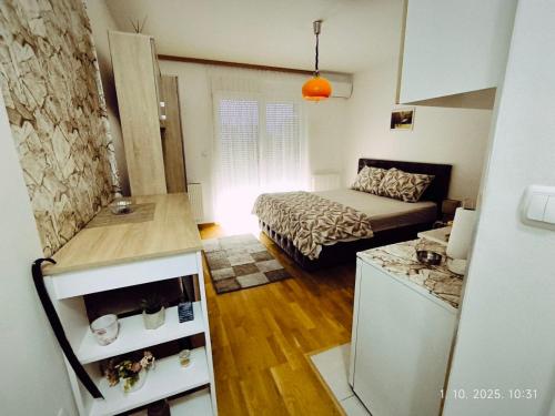 ein kleines Zimmer mit einem Bett und einer Küche in der Unterkunft Dunja Doboj in Doboj