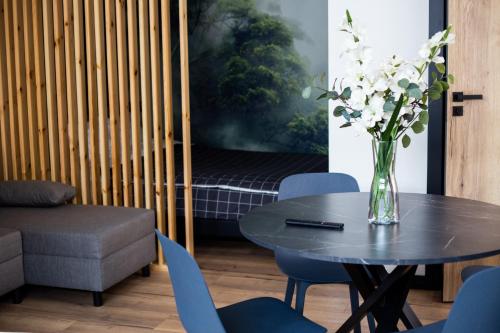 a vase of flowers sitting on a table with chairs at "Work and Quiet", Faktura VAT, KLIMATYZACJA, AIR CONDITIONING, GROUND FLOOR, PARKING, PARTER, in Kielce