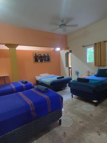 a room with two beds and two couches at La Casa Colorada in San Benito