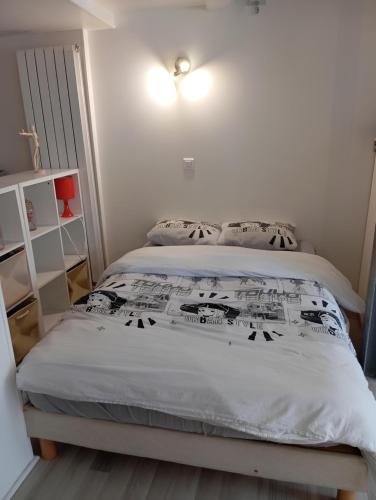 a bedroom with a bed with a white comforter at Studio Chavigny avec wifi in Chavigny
