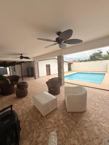 a living room with a ceiling fan and a swimming pool at Serenity House Antón in Coclé