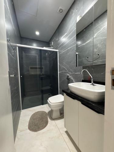 Un baño con inodoro, lavabo y ducha. en Casa Foz do Iguaçu Ipê, en Foz do Iguaçu