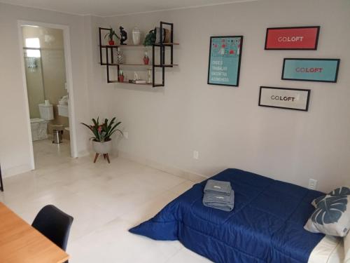 1 dormitorio con una manta azul en el suelo en Hospedagem e Coworking - suítes, en Anápolis