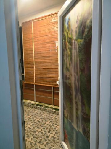 eine Tür, die in einen Raum mit einem Gemälde führt in der Unterkunft Yuvati Homestay in Bumlitan