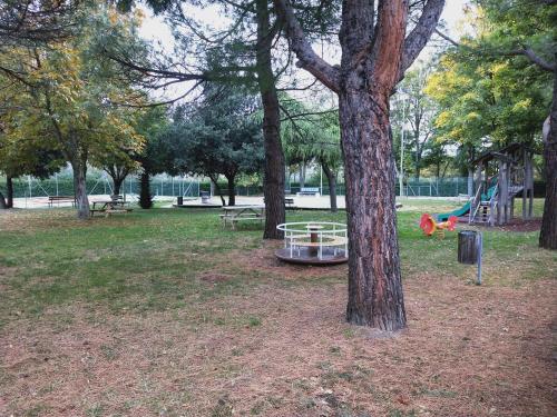 a park with a playground with a tree at La casetta del cacciatore 