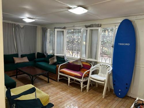 a living room with a couch and a surfboard at Cabanon pied sur mer in Mohammedia
