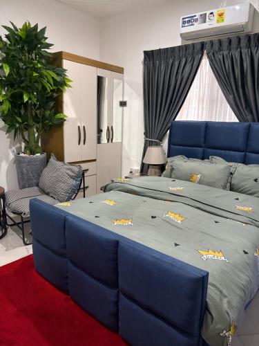a bedroom with a large bed with blue cushions at Nabs lodge in Kumasi