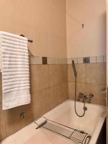a bathroom with a bath tub with a towel at Swanky Spectacular Hotel in Johannesburg