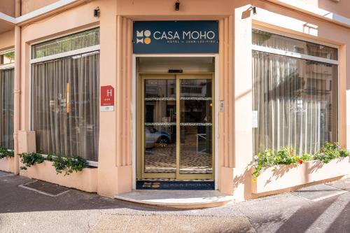胡安莱潘Hôtel CASA MOHO - Juan-Les-Pins的一栋有玻璃门的建筑物，里面停着一辆车。