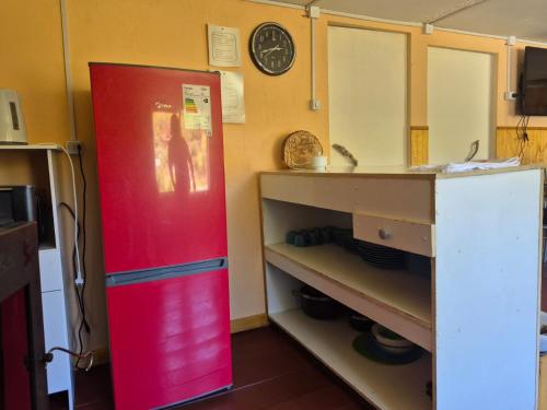 una nevera roja en una cocina junto a un mostrador en Cabaña el Sauco, en Puerto Guadal