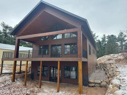 a large wooden house with a balcony on top at 5 Bdrm 12 Guest LakeHouse with Private Boat Dock in Round Lake Seaplane Base