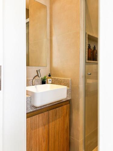 a bathroom with a white sink and a shower at Estúdio na melhor rua do Leblon in Rio de Janeiro