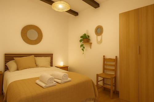 a bedroom with a bed with towels on it at Casa del Agua - Escapada rural con chimenea y vistas a Sierra Nevada in Abrucena