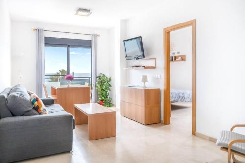 ein Wohnzimmer mit Sofa und Fernseher in der Unterkunft Apartamentos Varadero on the beach in La Cala del Moral