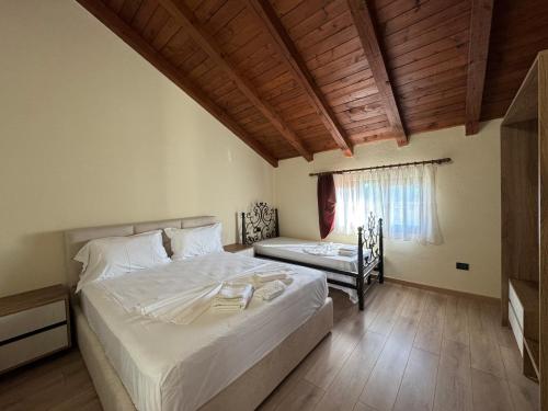 a bedroom with a large white bed and a window at Bujtina Tushaj in Lezhë