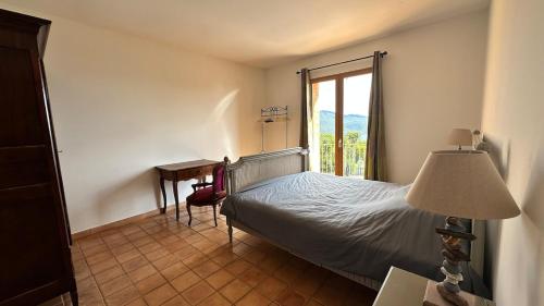 una camera da letto con un letto, una scrivania e una finestra di La Castagna Sea View Pool Villa a Coti-Chiavari
