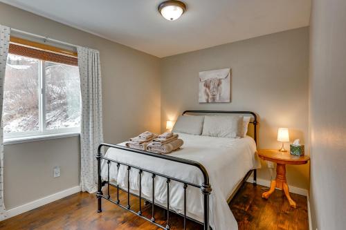 a bedroom with a bed and a window at Stunning Alaskan Getaway with River and Mtn Views in Eagle River