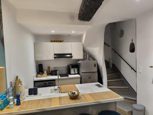 a kitchen with white cabinets and a table in a room at L'horizon De Coursan in Coursan