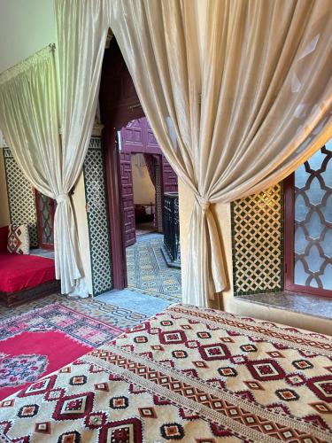 a bedroom with a bed and curtains in a room at Riad A La Belle Etoile in Salé
