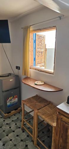 a room with a wooden table and a window at Room Taghazout in Taghazout