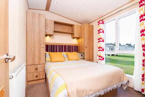 a bedroom with a bed and a large window at 3 Bedroom Static Caravan-Seton Sands in Port Seton