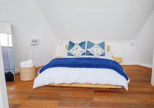 a bed with blue and white sheets and pillows at LUX IN THE AIR - An Elevated Experience on the Vaal Dam in Denysville