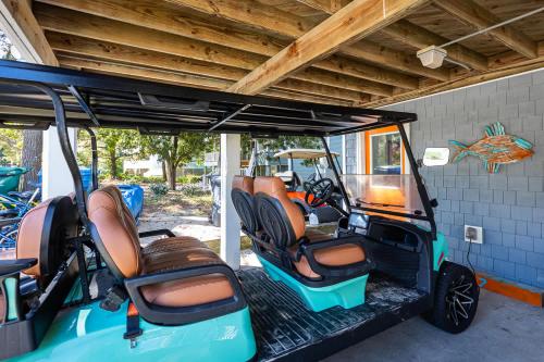 a golf cart with empty seats and a roof at Pool & Spa Game Rm Walking Distance to Beach & Shops in Duck