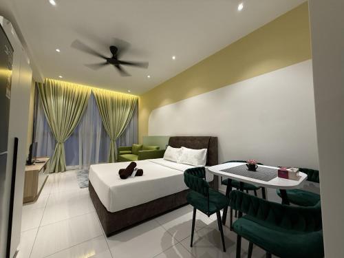 a bedroom with a bed and a table with chairs at Majestic Residance Luxury Suites By klcc in Gua Sai