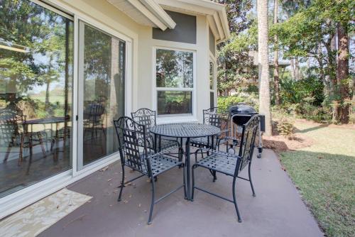 a patio with a table and chairs and a grill at Turnberry 8573 in Destin