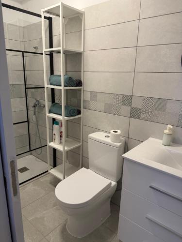a white bathroom with a toilet and a shower at Casa Sole in El Médano
