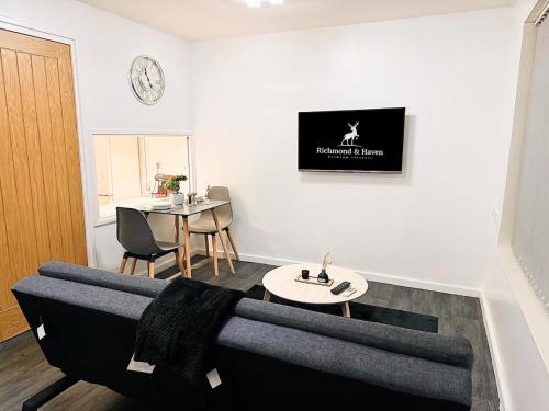 a living room with a couch and a table at Cosy 1 bed flat, sleeps 4, free parking in Bradford