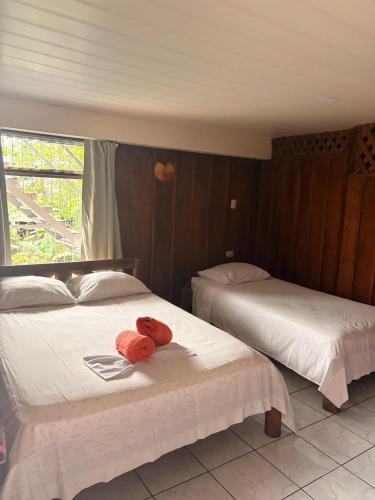 a bedroom with two beds with towels on them at Hospedaje Angeluz in Quesada