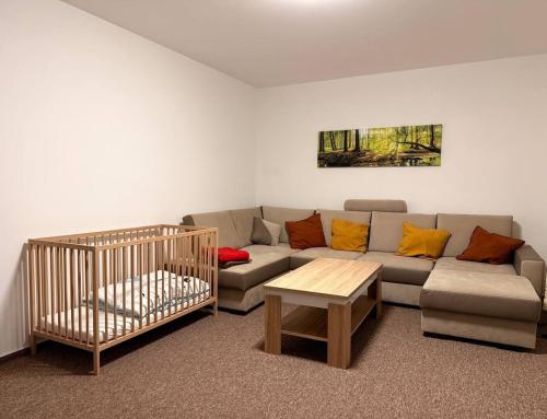 Una sala de estar con un sofá y una cuna. en Chata Vápenná, en Jeseník