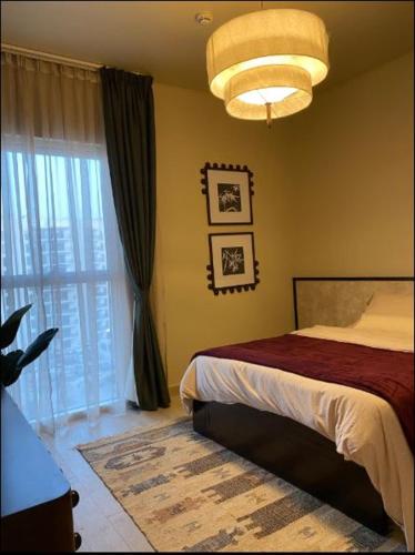 Un dormitorio con una cama y una ventana grande. en The Poet Den with 120 inch screen, en Yas Island