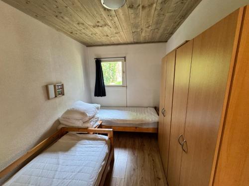 ein kleines Zimmer mit zwei Betten und einem Fenster in der Unterkunft Maison Annelore in Saint-Honoré-les-Bains