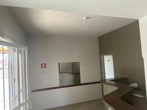an empty room with a mirror on the wall at Suíte 16 no centro da cidade in Uberaba