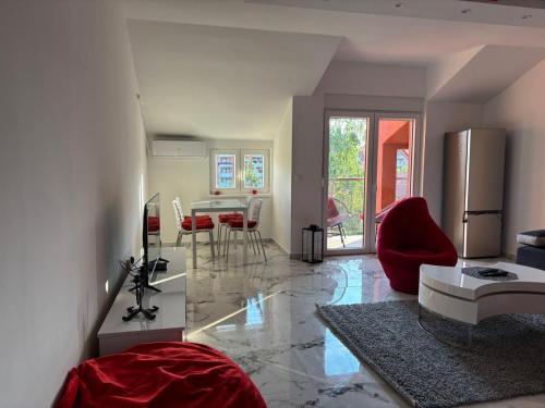 a kitchen and living room with a refrigerator and red chairs at Red room in Petrovac na Mlavi