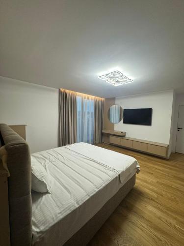 una camera da letto con un letto e una TV a schermo piatto di Knight Home a Voluntari